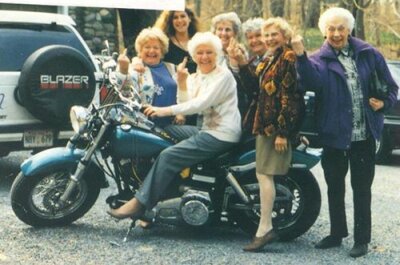 Бабки Байкеры возле мотоцикла показывают факи